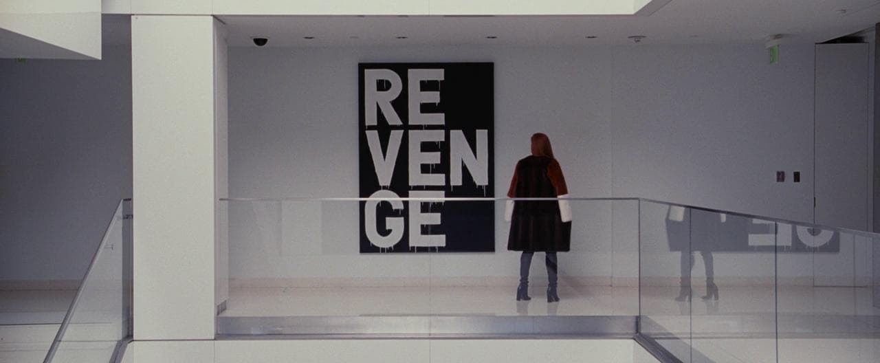a woman standing in a room with a large poster behind her