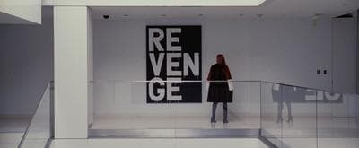 a woman standing in a room with a large poster behind her