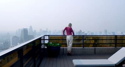 a woman standing on a balcony overlooking a city