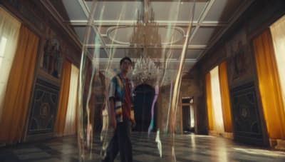 a man is standing in a room with a chandelier