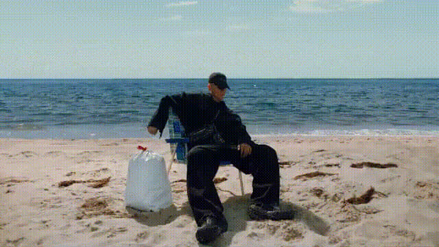 a man sitting in a chair on the beach