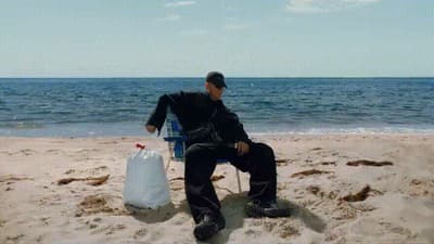 a man sitting in a chair on the beach