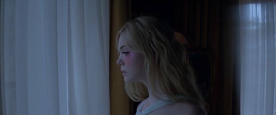 a young blonde girl looking out of a window