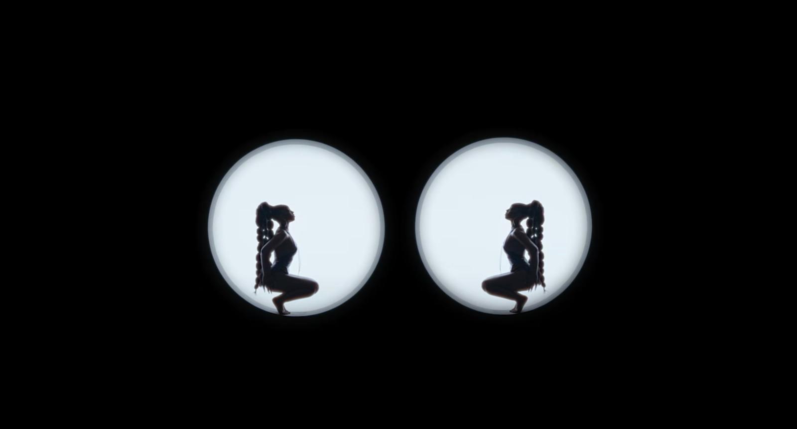 a silhouette of a woman doing yoga in front of a black background