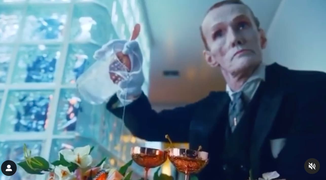 a man in a suit holding a glass of wine