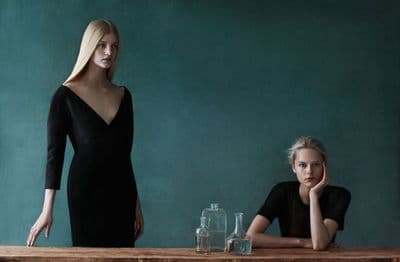 two women sitting at a table in front of a chalkboard