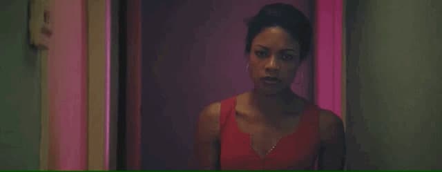 a woman in a red dress standing in a hallway