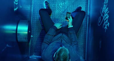 a man laying down on a train using a cell phone