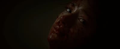 a close up of a woman's face covered in blood