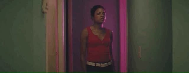 a woman in a red top standing in a hallway