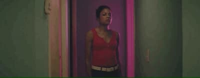 a woman in a red top standing in a hallway