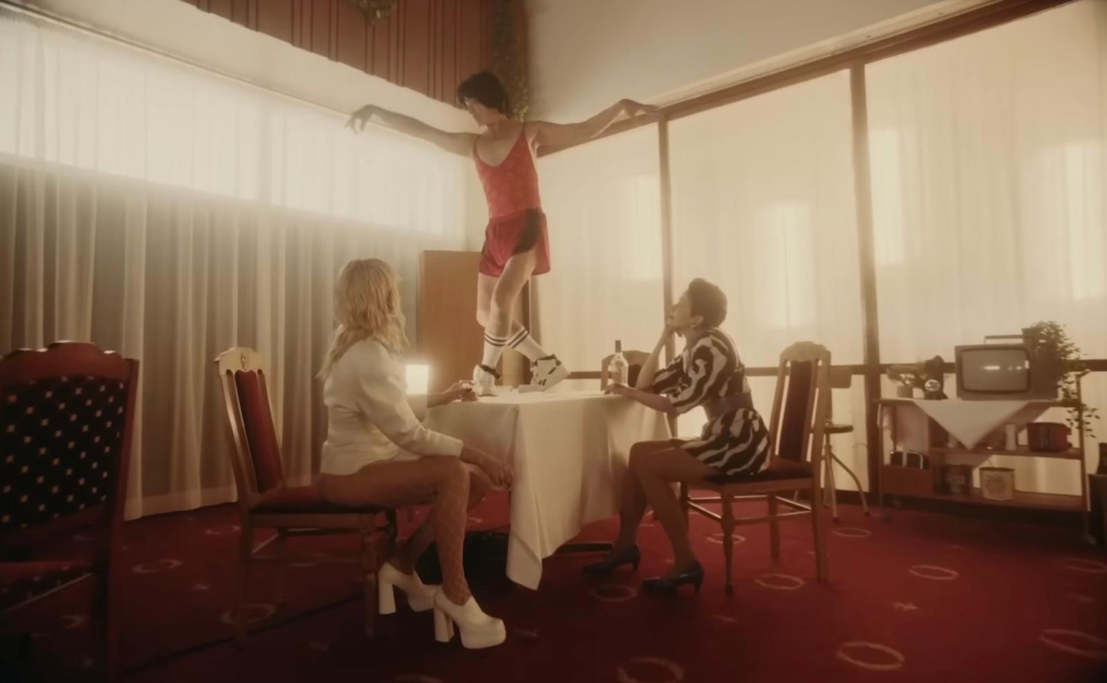 a woman standing on top of a chair next to a table