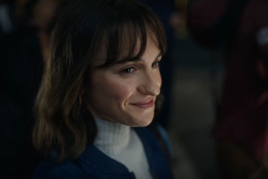 a woman is smiling in front of a crowd of people