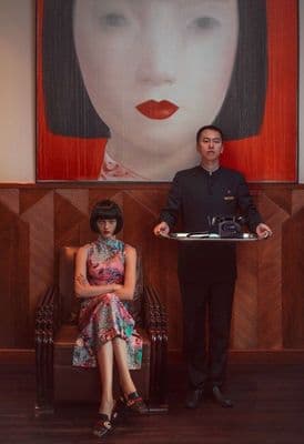 a man standing next to a woman holding a tray