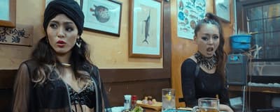 two women sitting at a table in a restaurant