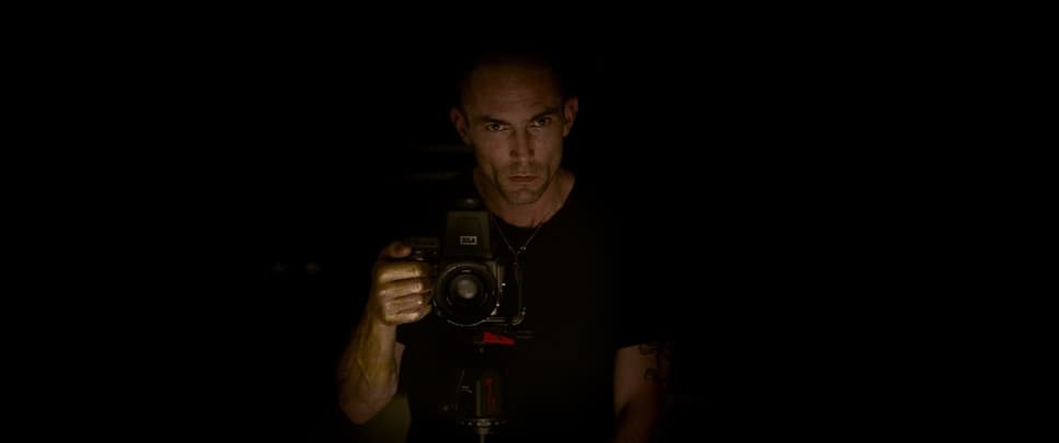 a man holding a camera in the dark