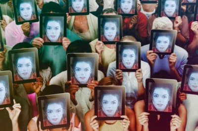 a group of people holding up pictures of themselves