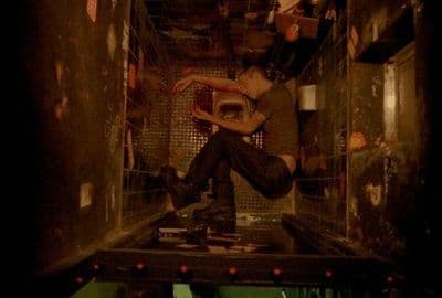 a man sitting on top of a metal cage