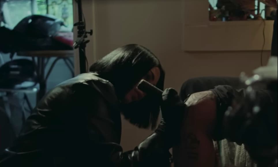 a woman is getting a tattoo in a room