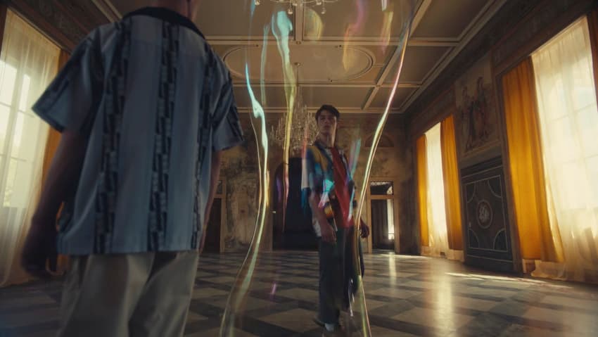 two men standing in a room with colorful lights