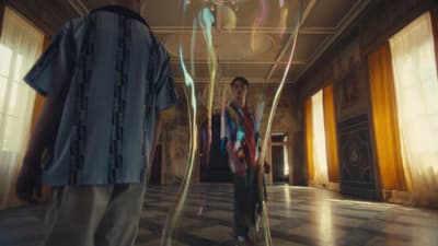 two men standing in a room with colorful lights