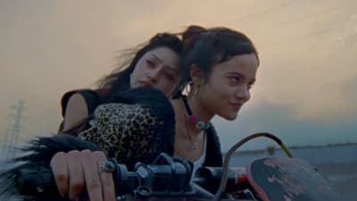 two women riding a motorcycle on a deserted road