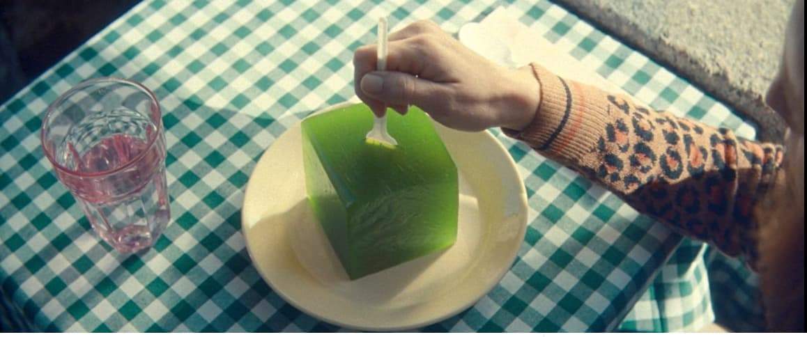 a person is holding a piece of green food on a plate