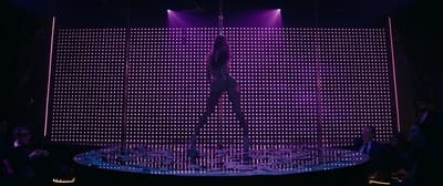 a person standing on a stage in front of a purple light