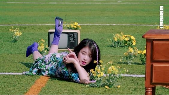 a woman laying on the ground next to a tv