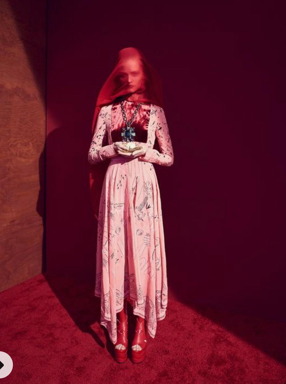 a woman in a pink dress standing in a room