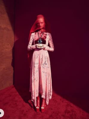 a woman in a pink dress standing in a room
