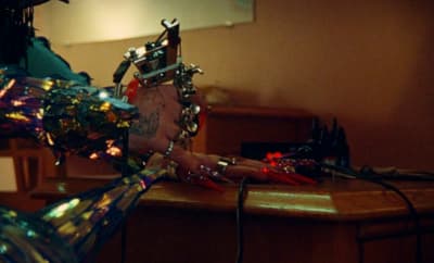 a woman in a futuristic outfit is holding a gun
