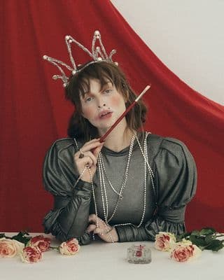 a woman with a crown on her head sitting at a table