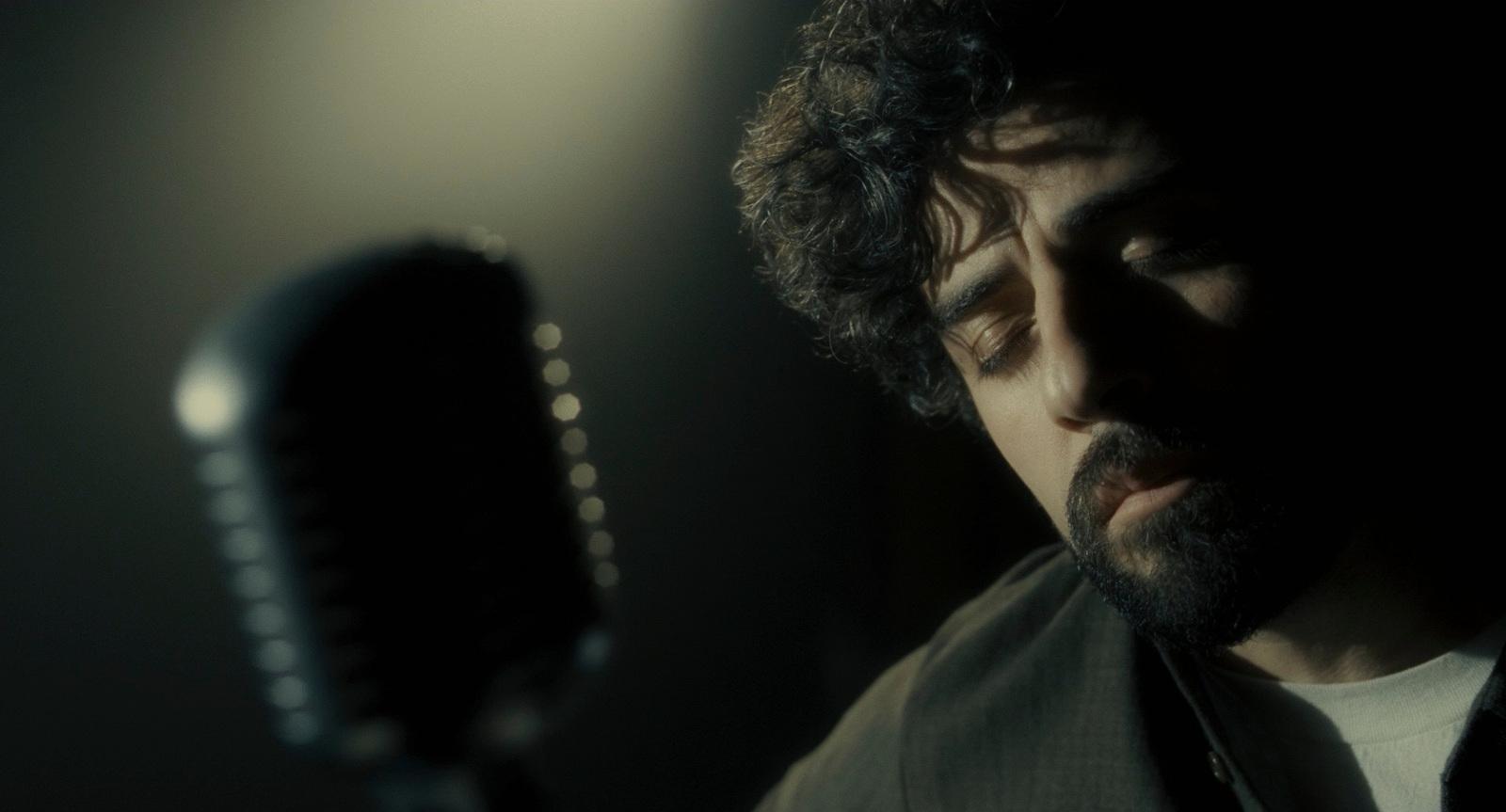 a man holding a microphone in a dark room