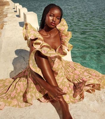 a woman sitting on a wall next to a body of water