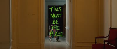 a woman standing in a doorway with a green sign on the door