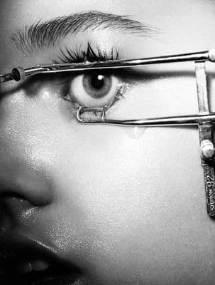 a woman with a pair of scissors on her eye
