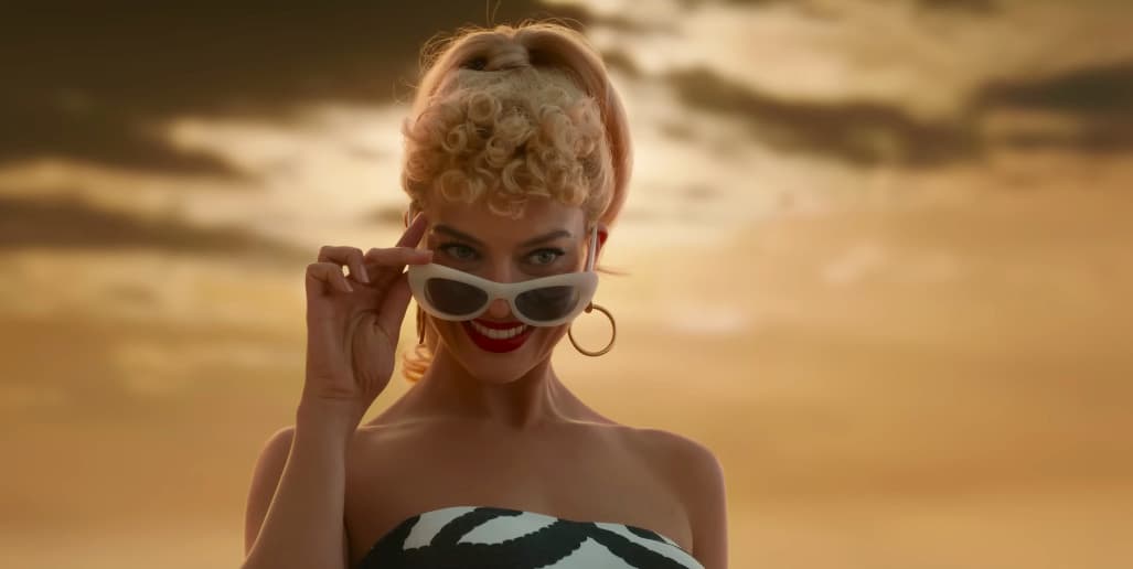 a woman wearing sunglasses and a bikini on the beach