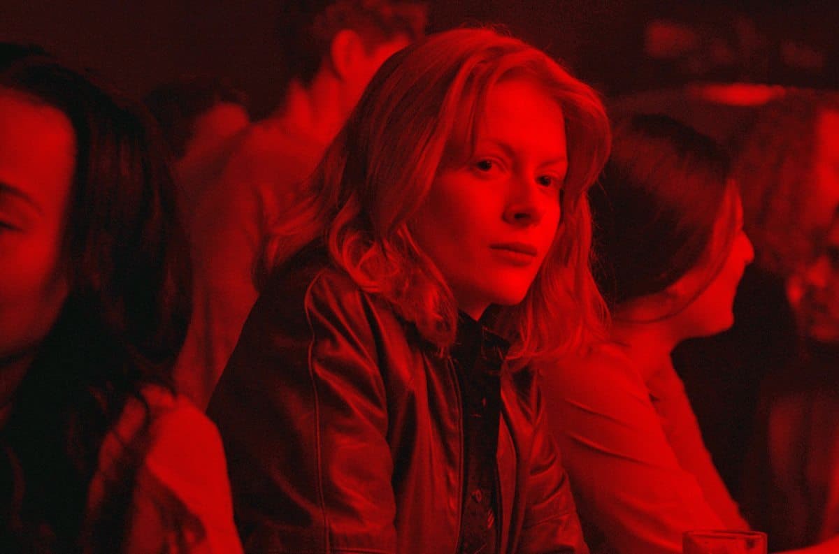 a woman sitting in a crowd of people in a red light
