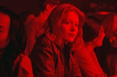 a woman sitting in a crowd of people in a red light