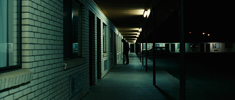 a dark hallway with a clock on the wall