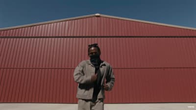a man standing in front of a red building