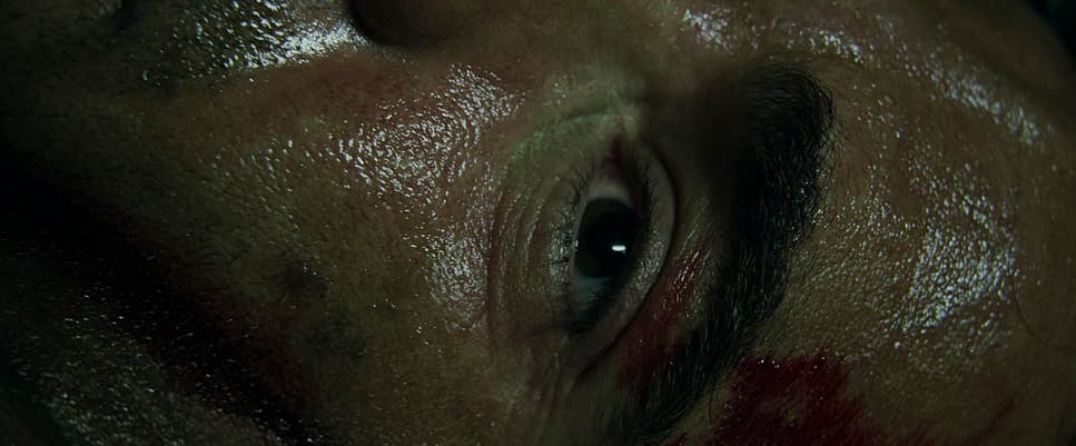 a close up of a man's face with a bleeding eye