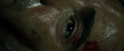 a close up of a man's face with a bleeding eye