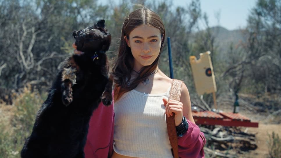 a woman holding a black cat in the desert