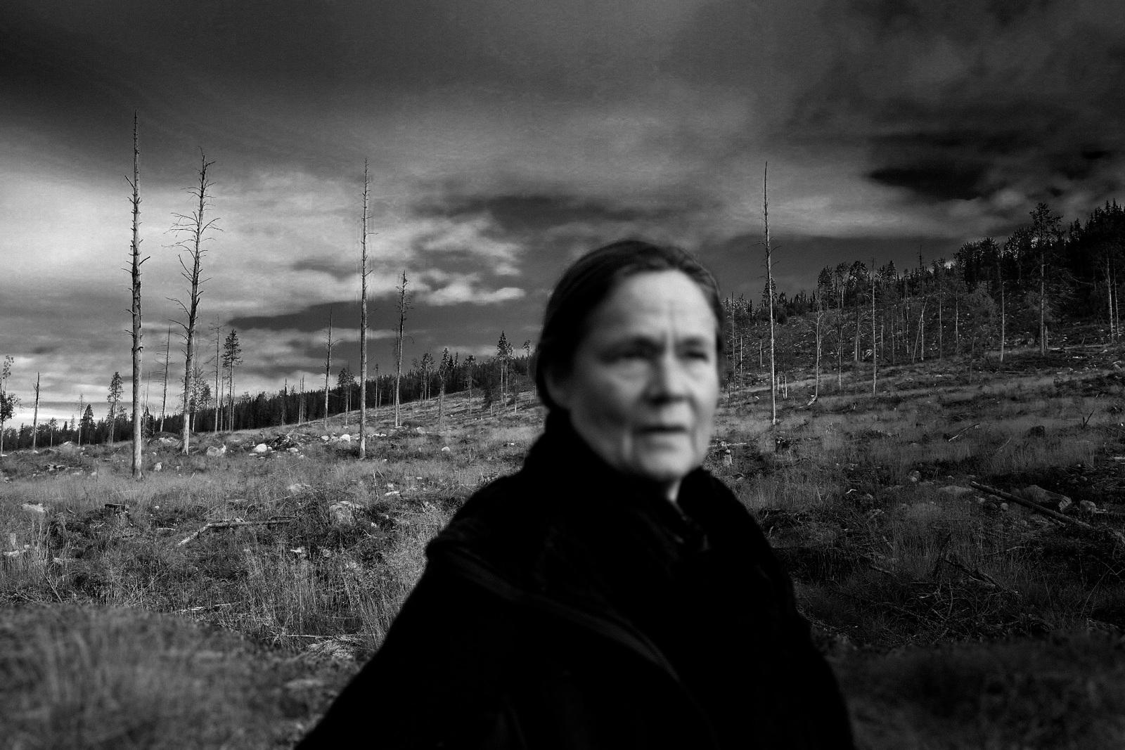 a black and white photo of a woman in a field