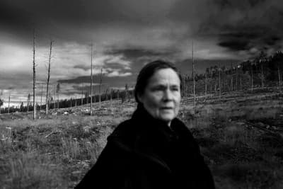 a black and white photo of a woman in a field