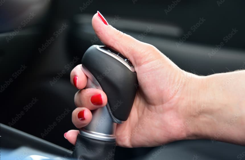 a woman's hand holding a remote control in a car