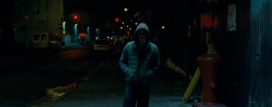 a man standing on a sidewalk in the dark