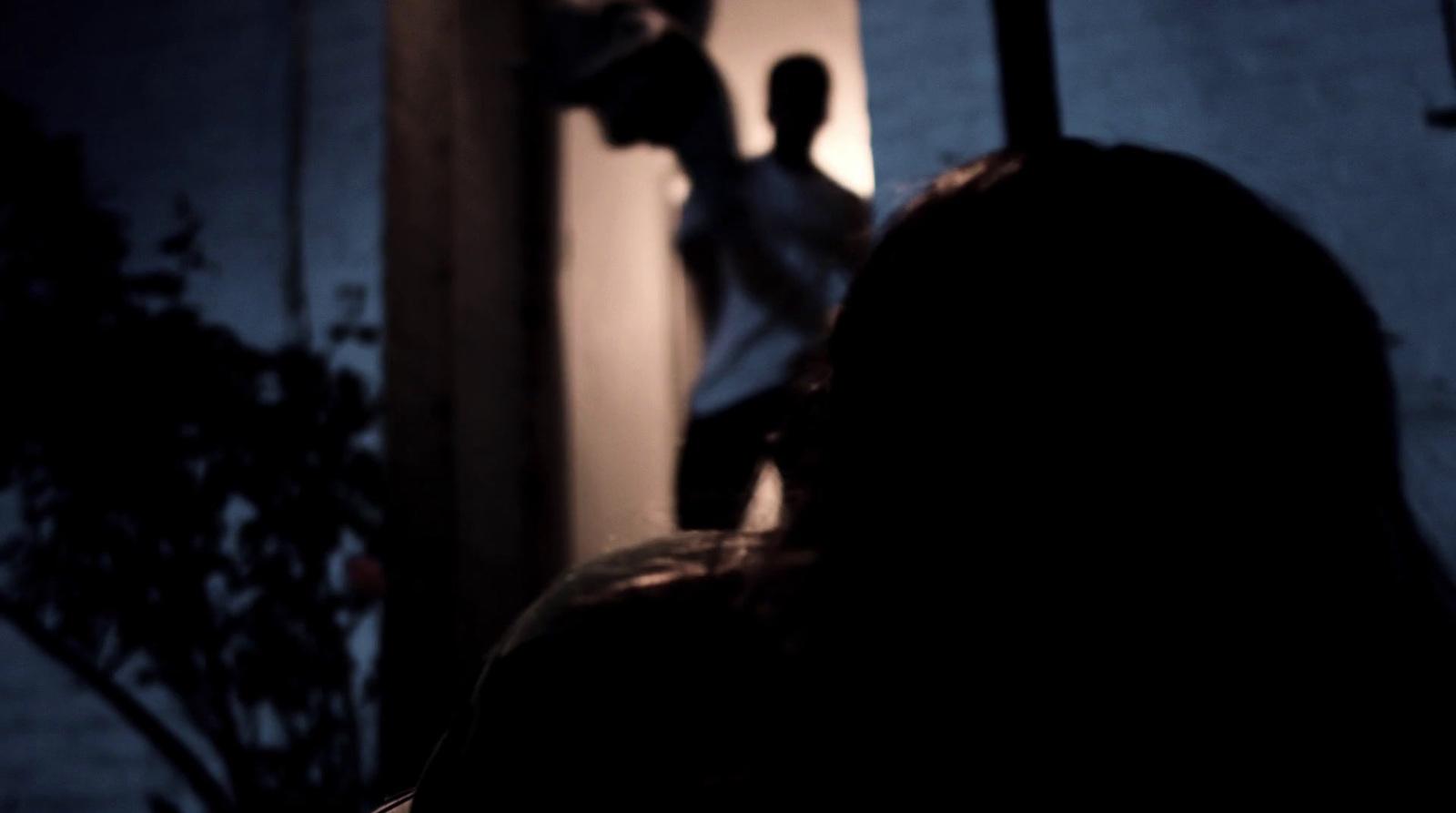 a person standing in front of a door in the dark